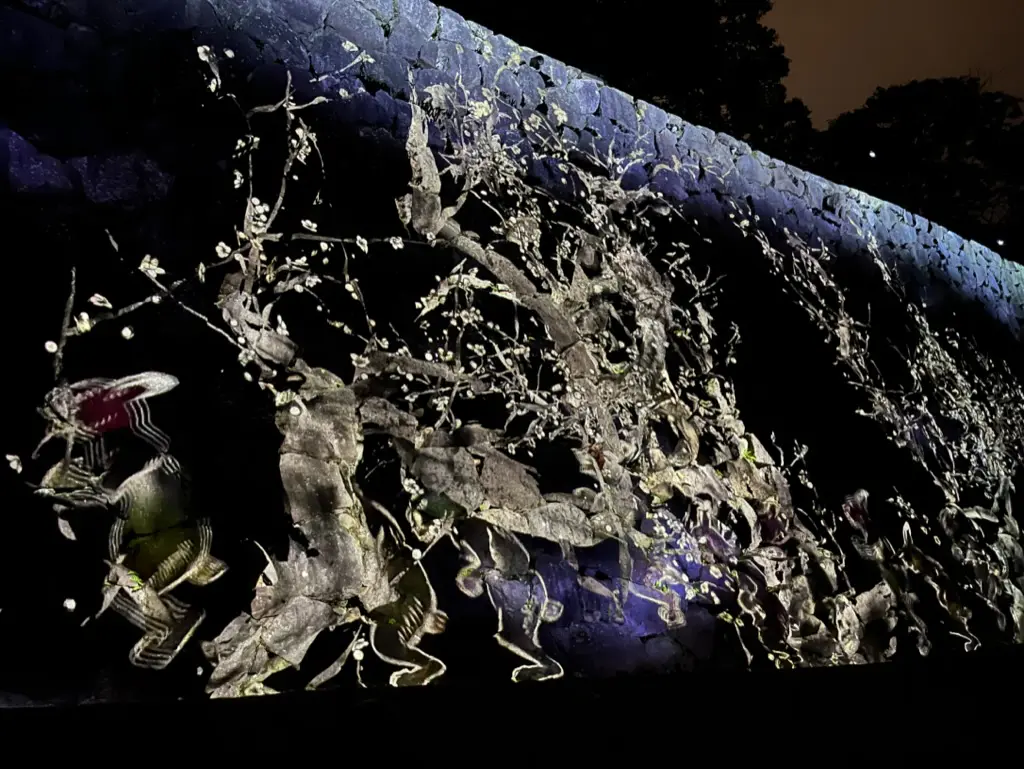 teamLab arts on the castle wall with animals marching